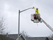 DJ’s Electrical lineman Rhett Lindberg of Winlock changes the current high-pressure sodium lights to new LED bulbs in Battle Ground.