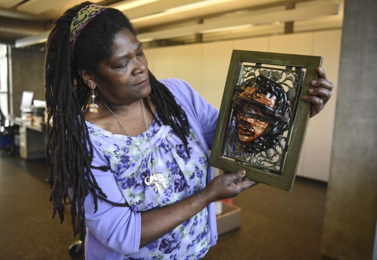 Artist Claudia Carter, who’s curated an exhibit at the Vancouver Community Library about “The History and Art of African-Americans in the Northwest” for the local NAACP, discusses her original ceramic piece called “Enslaved.” (Ariane Kunze/The Columbian)