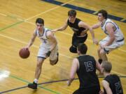 Hockinson’s Peyton Brammer (3) avoids Woodland’s Palmer Dinehart (15) and Wyatt Harsh (2) during a game at Hockinson High School, Friday January 19, 2018.