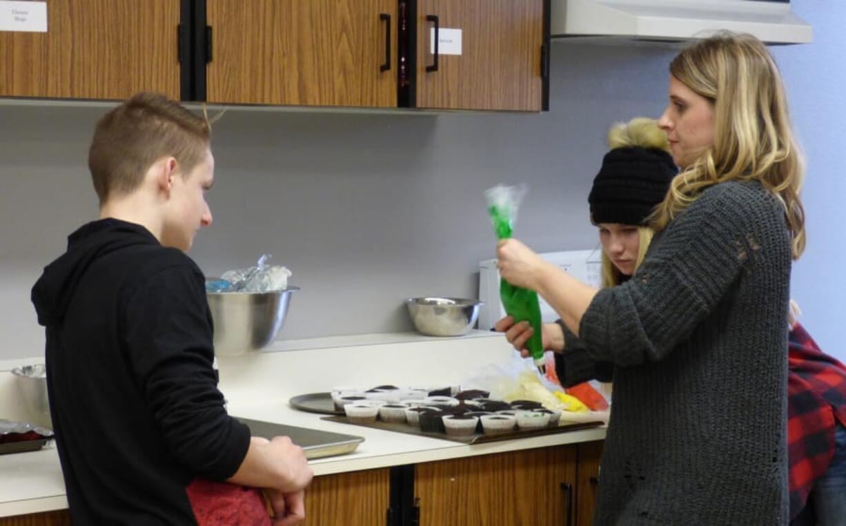 Ridgefield: Stefanie Foster, Ridgefield High School’s family and consumer science teacher, working with students during their Cupcake Wars competition, in which they had to research, bake and present a cupcake recipe.