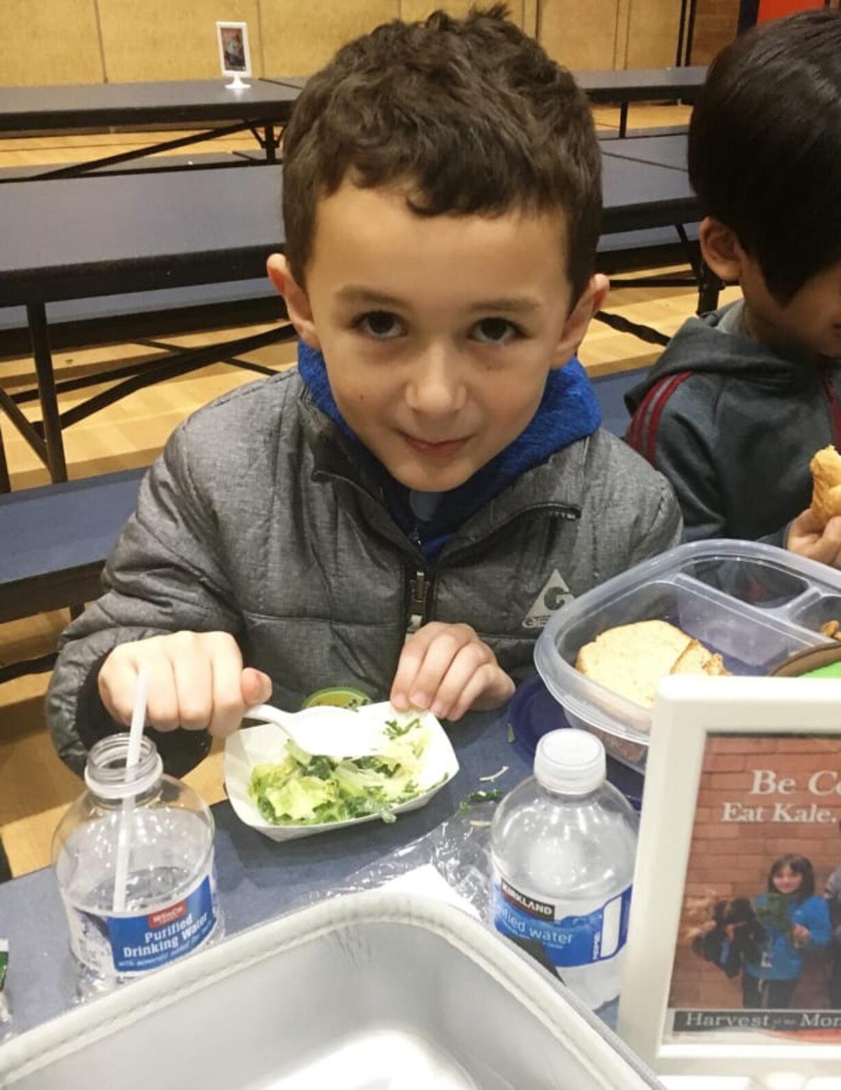 Five Corners: Sunset Elementary School student Cristian Trigueros tastes a Cool Kale Caesar Salad during lunch. Kale is the special ingredient this month at Evergreen Public Schools elementary schools through the Washington State University Extension’s Supplemental Nutrition Assistance Program Education’s Harvest of the Month program.