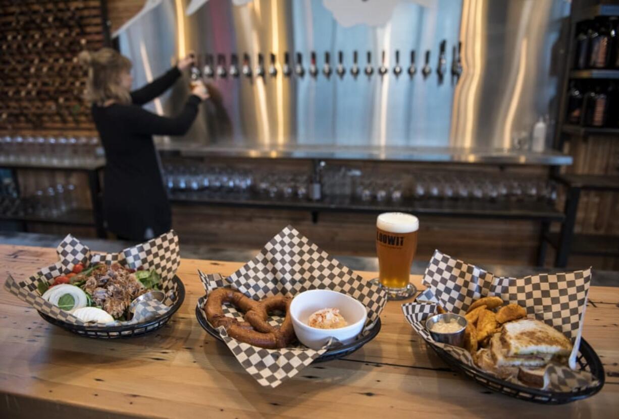 The house green salad with pulled pork, from left, the Spundekase, and the brewer’s grilled sandwich cheese with potato wedges at Loowit Brewing in downtown Vancouver.