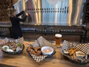 The house green salad with pulled pork, from left, the Spundekase, and the brewer’s grilled sandwich cheese with potato wedges at Loowit Brewing in downtown Vancouver.