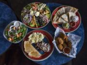 The Chef’s Salad, clockwise from top left, the chicken quesadilla, red stuffed jalapeño poppers and the steak strip dinner with a side salad are among the selections available at Out-A-Bounds Sports Bar & Grill in Vancouver.