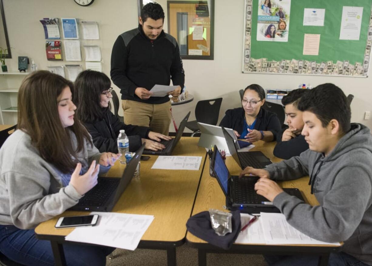 Evergreen High School students involved in Upward Bound, a college preparation program for first-generation college students, work on their résumés with guidance from Upward Bound Program Coordinator Arturo Santana, center left, and Upward Bound Program Director Maria Cabrera, center right, at Evergreen High School. Students do activities such as applying for scholarships, working on their résumés and visiting colleges through the new Upward Bound program housed at Evergreen High School.