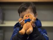 Joshua Kim of Camas, 3, holds his stuffed animal, Gingerbread Man, after picking him up from the library Thursday. Joshua brought Gingerbread Man because he was too nervous to leave another — his favorite — overnight, his mother said.