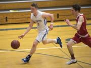 La Center's Saige Keep (3) dribbles down court followed by Columbia-White Salmon's William Gross (14) during Tuesday night's game at La Center High School on Jan. 30, 2018. La Center defeated Columbia-White Salmon 88-78.