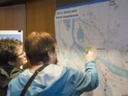 Anita Gillingham, left, looks on as Sharon Kenoski puts a red dot sticker on a map over the Interstate 5 Bridge to indicate the location of the most congested site along the drive into Portland. Clark County residents participated Tuesday in an open house held by the Oregon Department of Transportation to learn more and comment on the possibility of tolls on I-5 and I-205 at the state line down to where they connect south of Tualatin, Ore.