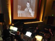 Comedian Charley Chase peers out at the audience at the Kiggins Theatre from a 1926 film called “Mighty Like a Moose,” while Rodney Sauer and a group from the Vancouver Symphony Orchestra provide the musical accompaniment. Right: Sauer, conductor and pianist, will lead members of the Vancouver Symphony Orchestra as they accompany a screening of “The Mark of Zorro” at the Kiggins Theatre on Sunday.