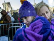 April Nickila and Christina Liesmaki try to stay warm while waiting in subzero temperatures to enter U.S. Bank Stadium to watch an NFL football game between the Chicago Bears and Minnesota Vikings, Sunday, Dec. 31, 2017, in Minneapolis.