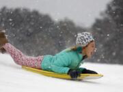 Finley Bork, 7, uses a boogie board, typically used on the beach, for sledding down a hill on a golf course at the Isle of Palms, S.C., Wednesday, Jan. 3, 2018.  A brutal winter storm smacked the coastal Southeast with a rare blast of snow and ice Wednesday, hitting parts of Florida, Georgia and South Carolina with their heaviest snowfall in nearly three decades.