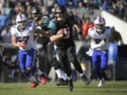 Jacksonville Jaguars quarterback Blake Bortles (5) rushes for yardage past Buffalo Bills outside linebacker Lorenzo Alexander (57) and free safety Jordan Poyer (21) in the first half of an NFL wild-card playoff football game, Sunday, Jan. 7, 2018, in Jacksonville, Fla. (AP Photo/Phelan M.