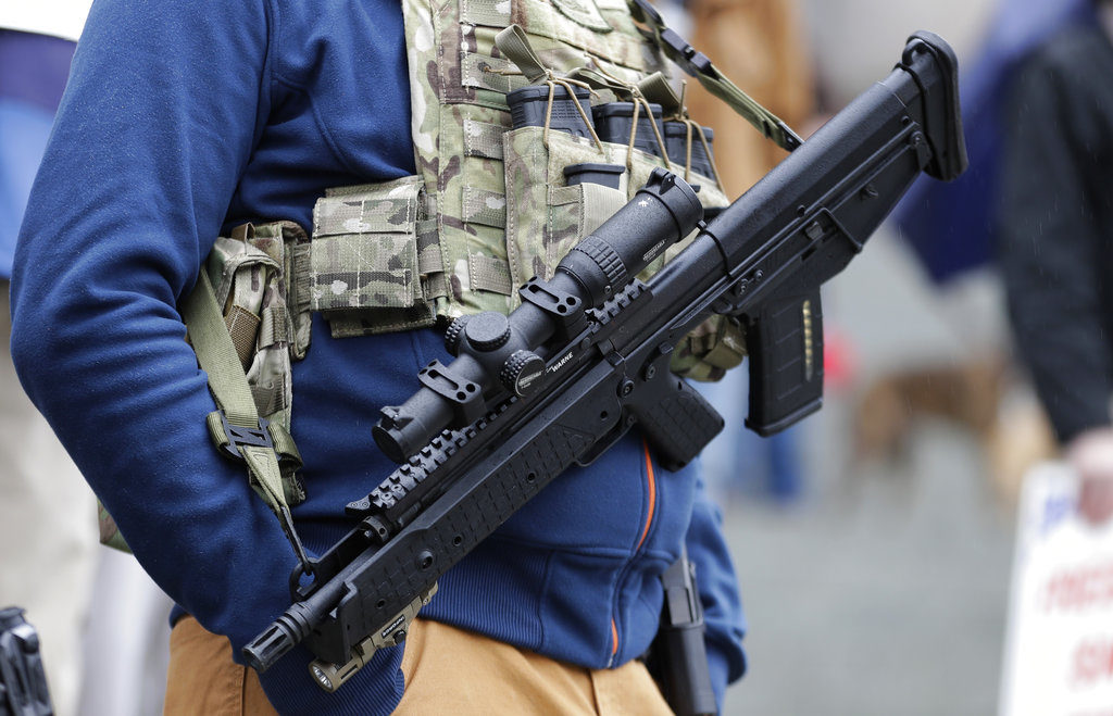 Ben Garrison, of Puyallup, wears his Kel-Tec RDB gun, and several magazines of ammunition, during a gun rights rally at the Capitol in Olympia, Wash, in 2018. (AP Photo/Ted S.