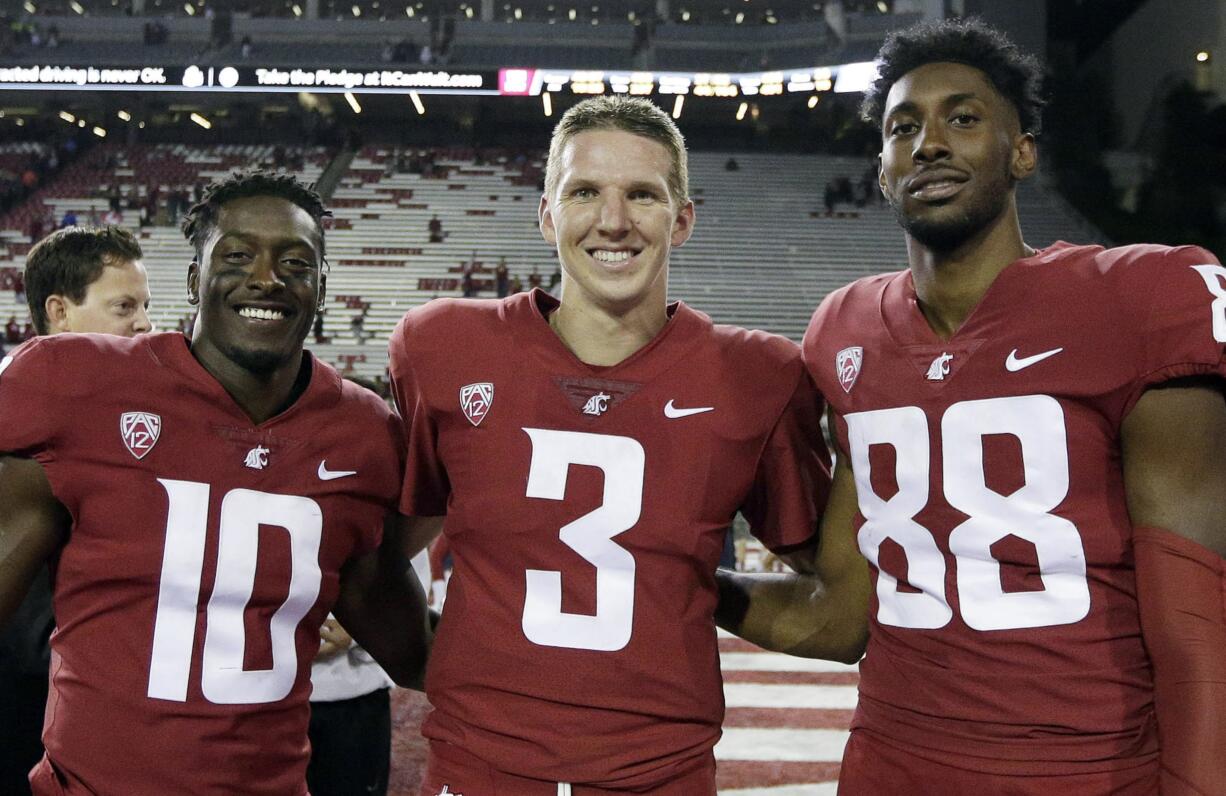 FILE - In this Sept. 9, 2017, file photo, Washington State defensive back Kirkland Parker (10), quarterback Tyler Hilinski (3) and wide receiver CJ Dimry (88) pose for a photo after an NCAA college football game against Boise State in Pullman, Wash. Hilinski has died from an apparent self-inflicted gunshot wound. The 21-year-old Hilinski was discovered in his apartment after he didn't show up for practice Tuesday, Jan. 16, 2018.