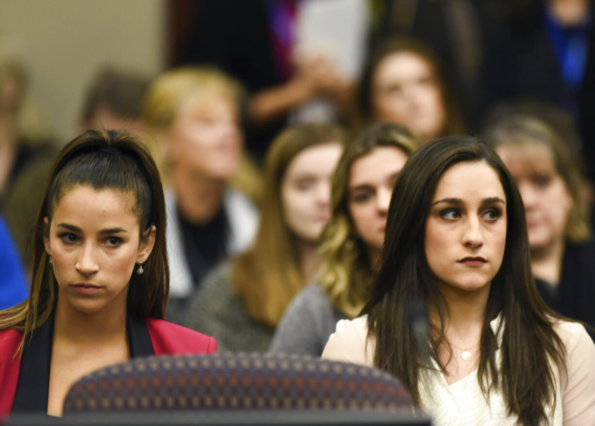 Former Olympians Aly Raisman, left, and Jordyn Wieber sit in Circuit Judge Rosemarie Aquilina's courtroom during the fourth day of sentencing for former sports doctor Larry Nassar, who pled guilty to multiple counts of sexual assault, Friday, Jan. 19, 2018, in Lansing, Mich.