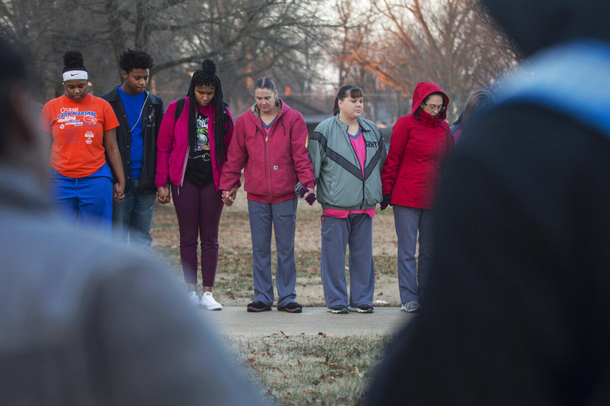 Students and community members hold hands in prayer before classes at Paducah Tilghman High School in Paducah, Ky., Wednesday, Jan. 24, 2018. The gathering was held for the victims of the Marshall County High School shooting on Tuesday.