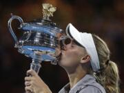 Denmark's Caroline Wozniacki kisses her trophy after defeating Romania's Simona Halep during the women's singles final at the Australian Open tennis championships in Melbourne, Australia, Saturday, Jan. 27, 2018.