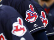 Members of the Cleveland Indians wear uniforms featuring mascot Chief Wahoo as they stand on the field for the national anthem before a baseball game against the Baltimore Orioles in Baltimore. The Cleveland Indians are taking the divisive Chief Wahoo logo off their jerseys and caps, starting in 2019.