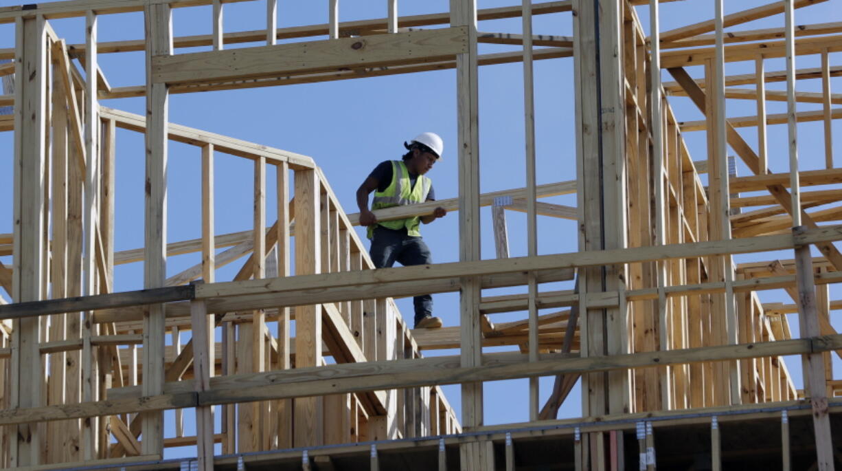 In this Friday, Oct. 6, 2017, photo, workers build an apartment and retail complex in Nashville, Tenn. On Friday, Jan. 26, 2018, the Commerce Department issues the first estimate of how the U.S. economy performed in the October-December quarter.