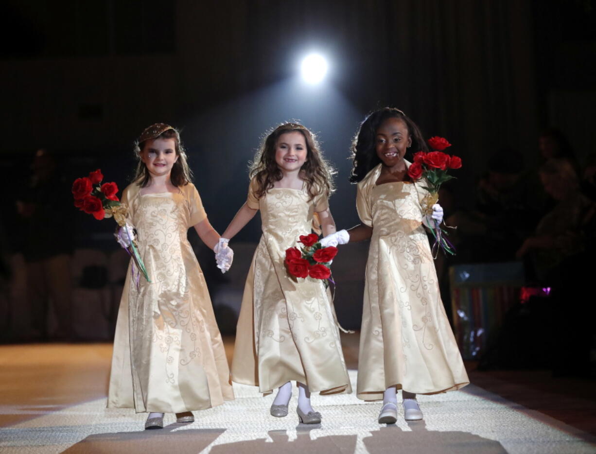 The ladies in waiting of the royal court of the Krewe of Little Rascals walk for the audience during their Mardi Gras Ball in Kenner, La., Thursday, Jan. 25, 2018. The more than 200 kids riding in Sunday’s Mardi Gras parade participated in a glitzy ball held in their honor.