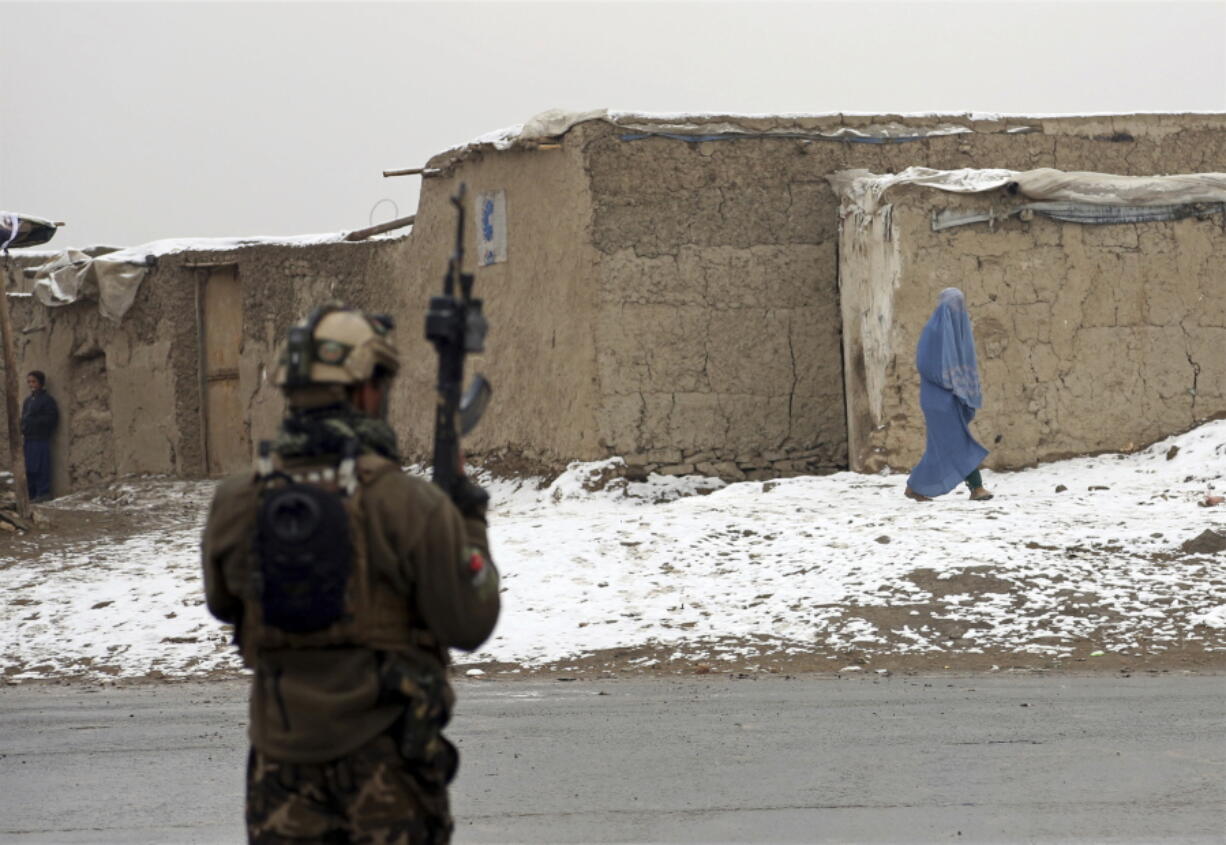 An Afghan woman leaves the site of an attack at the Marshal Fahim academy in Kabul, Afghanistan, on Monday. Islamic State militants attacked Afghan soldiers guarding the military academy in the capital Kabul on Monday, killing at least 10 troops and wounding 16.