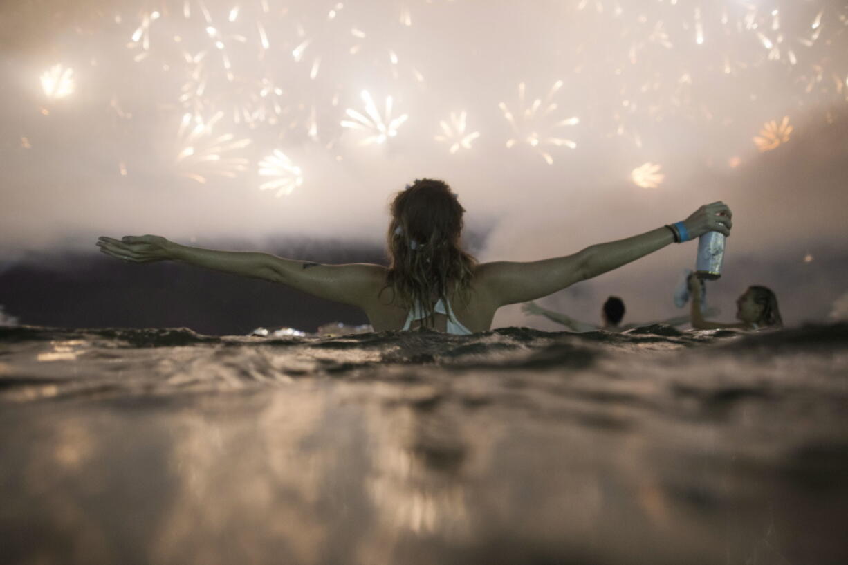 FILE - In this Jan. 1, 2018 file photo, people watch fireworks exploding over Copacabana beach during New Year’s celebrations in Rio de Janeiro, Brazil. Starting Thursday, Jan. 25, Brazil is making it easier and cheaper for Americans to apply for a visa following a decline in the number of visitors from the U.S.