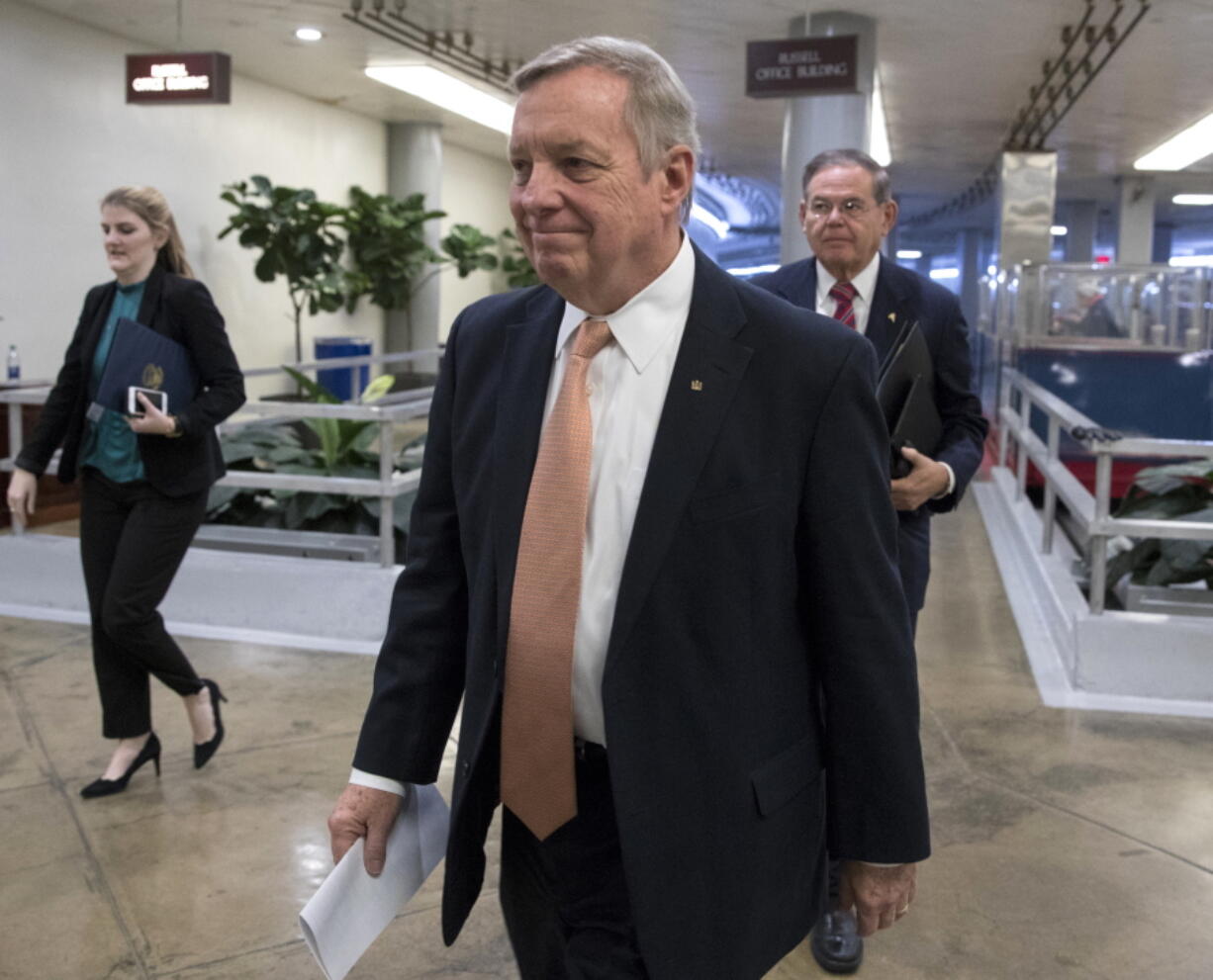 Sen. Dick Durbin, D-Ill., followed by Sen. Bob Menendez, D-N.J., walks to the Senate as Congress moves closer to the funding deadline to avoid a government shutdown, at the Capitol in Washington, Thursday, Jan. 18, 2018. (AP Photo/J.