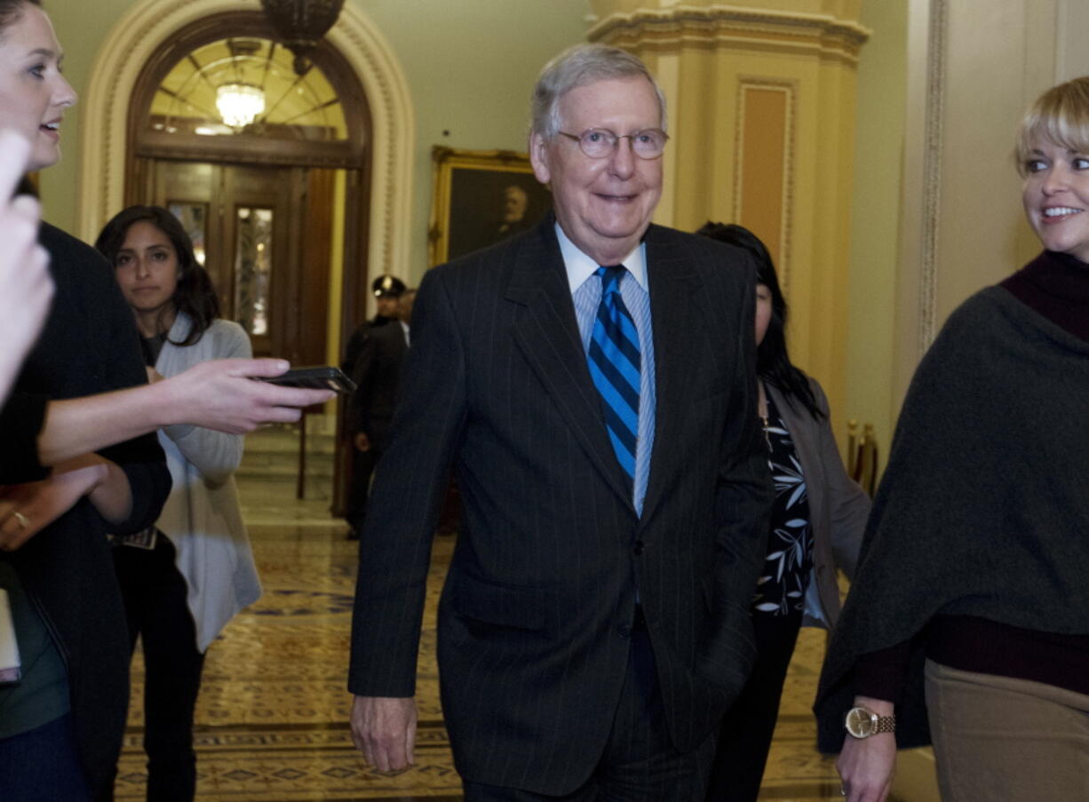 Senate Majority Leader Mitch McConnell, R-Ky., listens to questions from reporters Sunday as he walks to his office after speaking on the Senate floor in Washington.