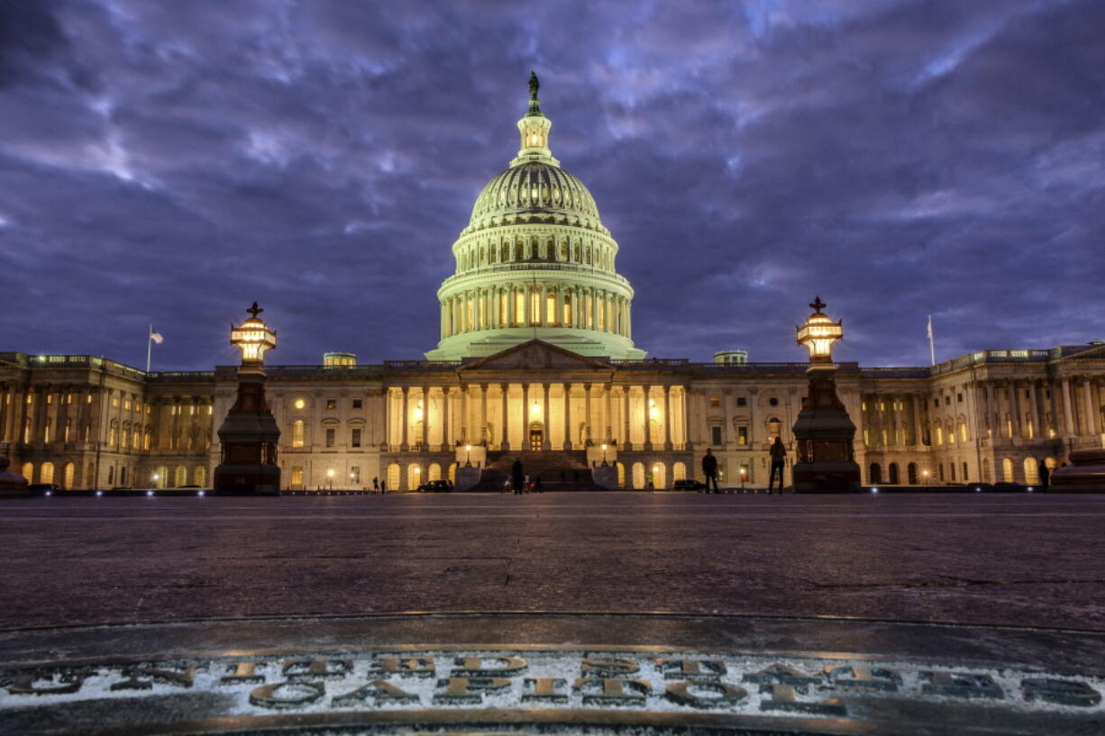 In this Jan. 21, 2018, photo, lights shine inside the U.S. Capitol Building as night falls in Washington. President Donald Trump will deliver his first State of the Union address Tuesday night but, as always, lawmakers are angling to steal part of the spotlight. Many female Democratic lawmakers plan to follow the lead of celebs at this year’s Golden Globe Awards by wearing black to the State of the Union. (AP Photo/J.