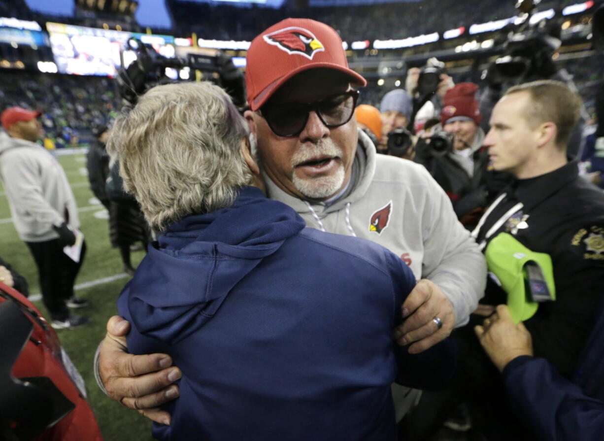 Arizona Cardinals head coach Bruce Arians, front right, hugs Seattle Seahawks head coach Pete Carroll, left, after an NFL football game, Sunday, Dec. 31, 2017, in Seattle.