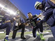 Seattle Seahawks quarterback Russell Wilson (3) prays with Austin Davis (6) and Pastor Judah Smith, second from left, after the team lost to the Arizona Cardinals in an NFL football game, Sunday, Dec. 31, 2017, in Seattle.