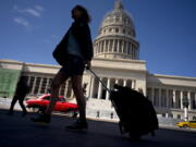 A tourist walks in front of the Capitolio on Thursday in Havana, Cuba.