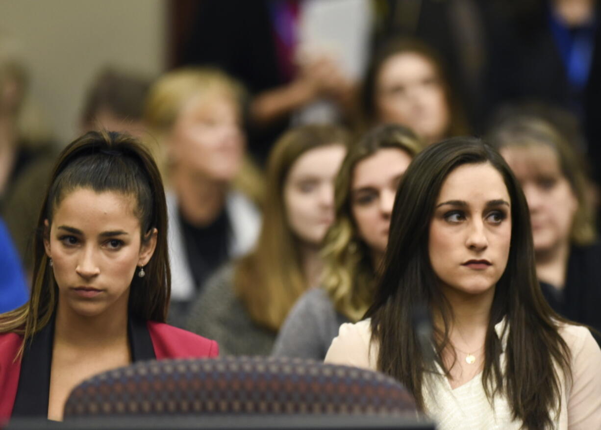 Former Olympians Aly Raisman, left, and Jordyn Wieber sit in court Friday on the fourth day of sentencing for former sports doctor Larry Nassar, who pleaded guilty to multiple counts of sexual assault in Lansing, Mich.