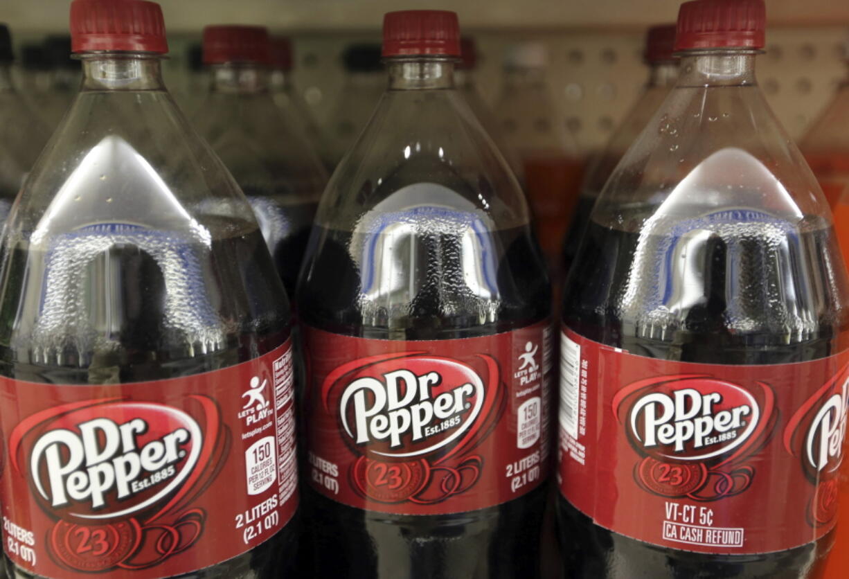 FILE - This April 28, 2016, file photo shows bottles of Dr. Pepper on a store shelf at Quality Cash Market in Concord, N.H. Keurig is buying Dr. Pepper Snapple Group Inc. to create a beverage business with approximately $11 billion in annual sales, announced Monday, Jan. 29, 2018.