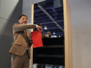 Seven Dreamers CEO Shin Sakane demonstrates use of the Laundroid, a laundry folding machine, at CES International, Wednesday, Jan. 10, 2018, in Las Vegas. (AP Photo/Jae C.