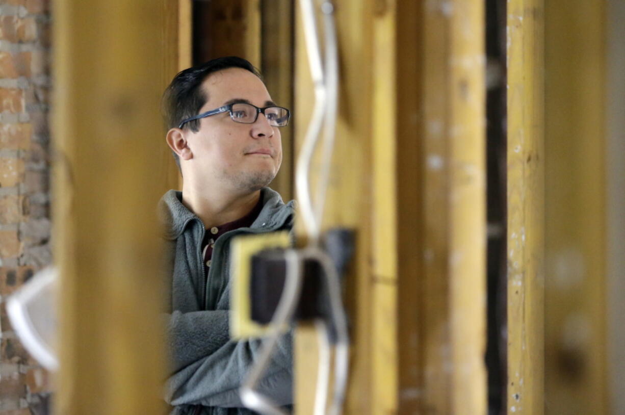 Jacob Lerma looks at the bare studs inside his home, which was damaged by floodwaters from Hurricane Harvey, Monday, Jan. 22, 2018, in Friendswood, Texas. Five months after Hurricane Harvey damaged thousands of houses in Texas, financial difficulties many homeowners still face as they work to rebuild has created a spike in missed mortgage payments. (AP Photo/David J.