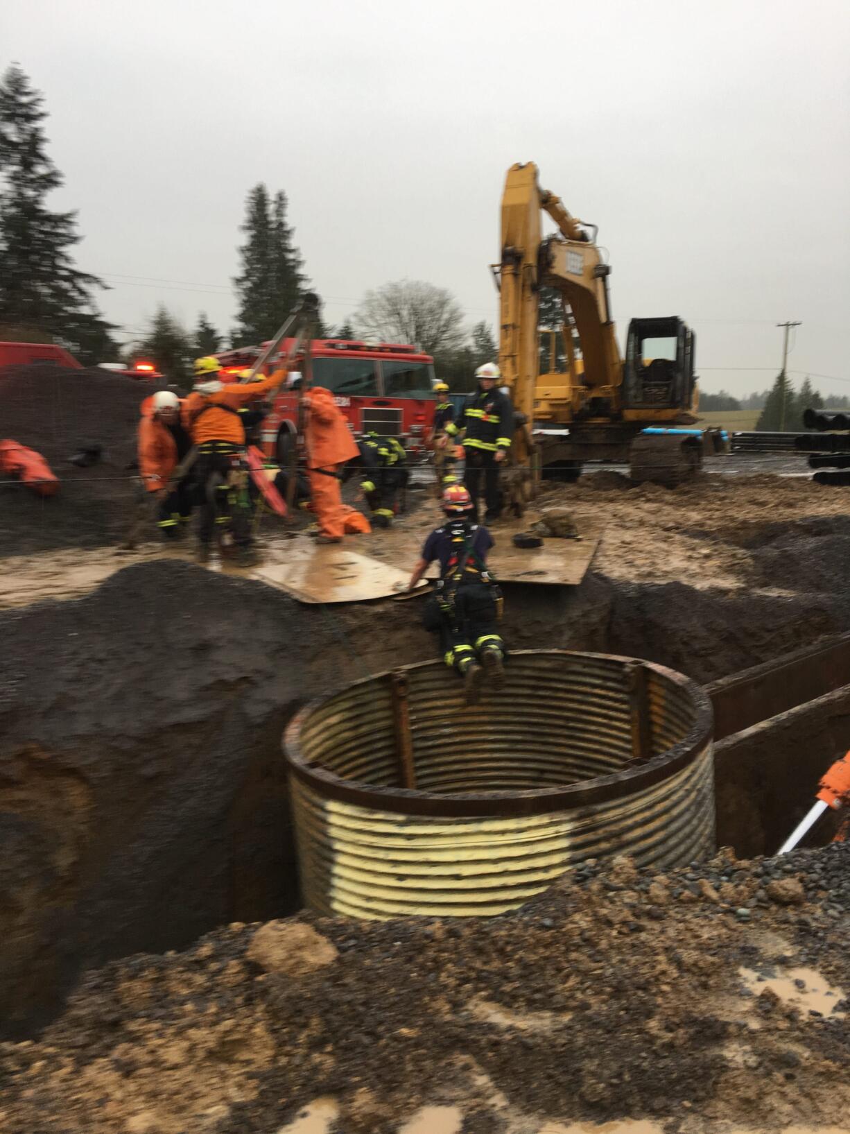 Firefighters work to extract a hurt worker from a hole at a construction site south of Ridgefield Monday afternoon.