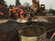 Firefighters work to extract a hurt worker from a hole at a construction site south of Ridgefield Monday afternoon.