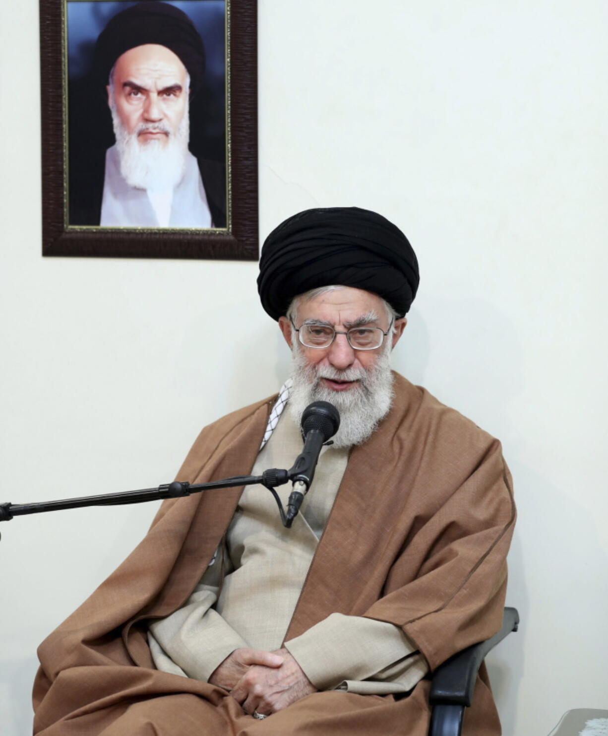 Supreme Leader Ayatollah Ali Khamenei speaks in a meeting as he sits under a portrait of the late Iranian revolutionary founder Ayatollah Khomeini, in Tehran, Iran, on Tuesday. Khamenei said Tuesday that the country’s enemies have meddled in recent protest rallies. The report on the website of Ayatollah Ali Khamenei quoted him as saying “in recent days” enemies of Iran have utilized various means including money, weapons, politics and intelligence apparatuses.