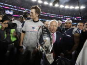 New England Patriots owner Robert Kraft, center, carries the trophy between quarterback Tom Brady, left, and safety Patrick Chung as they leave the field after the AFC championship NFL football game against the Jacksonville Jaguars, Sunday, Jan. 21, 2018, in Foxborough, Mass. The Patriots won 24-20. (AP Photo/David J.