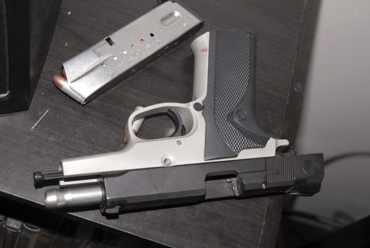 This 2014 photo provided by the Yakima Police Department shows a Smith & Wesson 9-mm pistol on a table in the apartment where Kyle Juhl used it to kill himself in Yakima, Wash. The pistol that Juhl used to kill himself was familiar to law enforcement: The Washington State Patrol had seized it years earlier while investigating a crime and then arranged its sale back to the public. It eventually fell into Juhl’s hands, illegally.