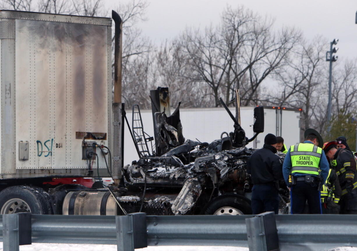 Emergency personnel confer over a tractor trailer cab and another vehicle involved in a fatal wreck along eastbound Interstate 64, on Tuesday in Town and Country, Mo. Authorities say at least two people are dead after a car and tractor-trailer collided in a crash involving at least 15 vehicles in suburban St. Louis. (Christian Gooden/St.