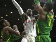 Arizona guard Rawle Alkins (1) drives between Oregon forward Troy Brown and Kenny Wooten (1) in the second half during an NCAA college basketball game, Saturday, Jan. 13, 2018, in Tucson, Ariz.