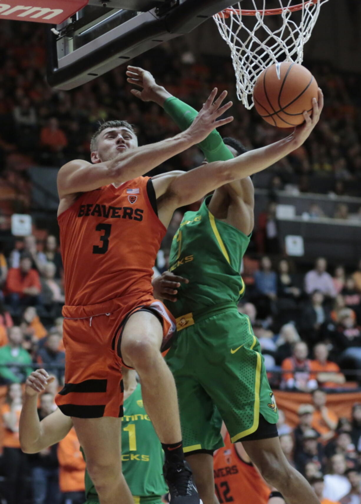 Oregon State’s Tres Tinkle (3) gets to the basket past Oregon’s Kenny Wooten (1) in the first half Friday. Tinkle had 19 points and 12 rebounds in the Beavers’ victory. Timothy J.