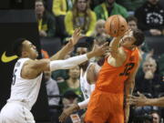 Oregon’s Elijah Brown, left, and Troy Brown Jr., center, battle Oregon State’s Ben Kone for a rebound during the first half of an NCAA college basketball game Saturday, Jan. 27, 2018, in Eugene, Ore.