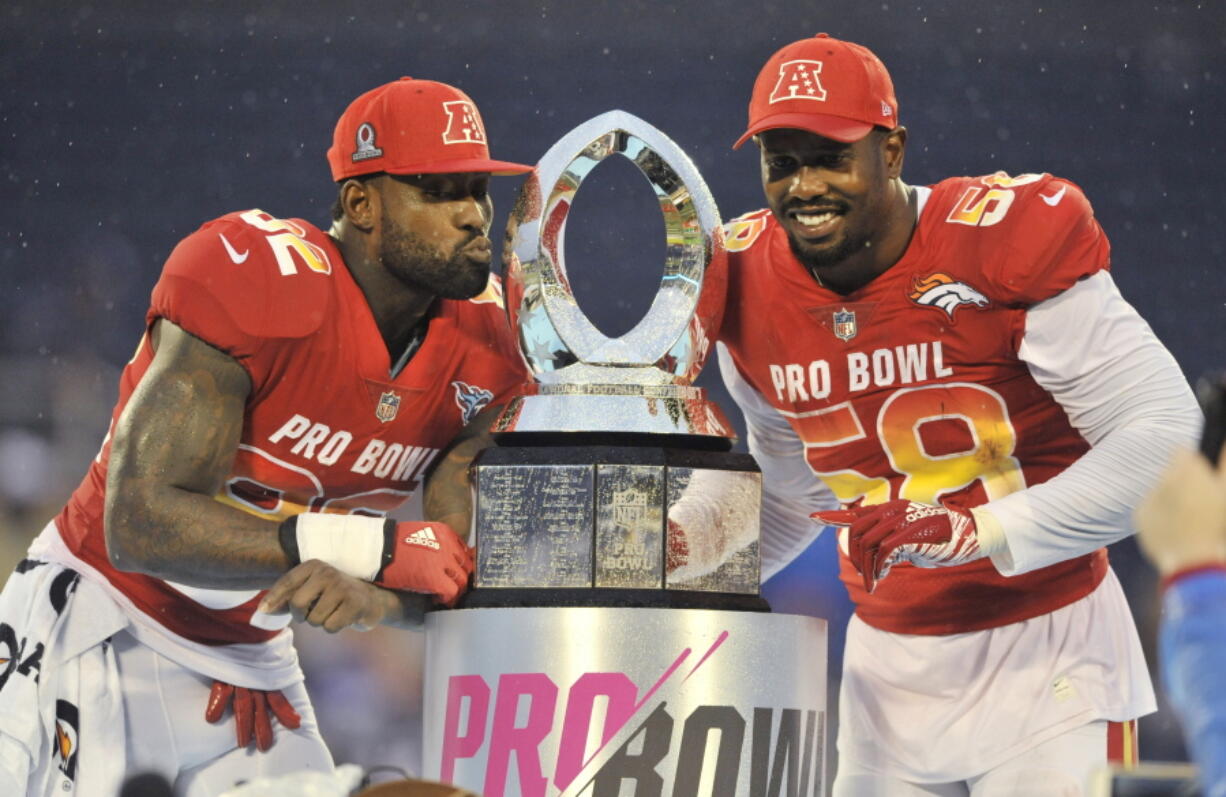 AFC linebacker Von Miller (58), of the Denver Broncos and tight end Delanie Walker (82), of the Tennessee Titans, pose with the NFL Pro Bowl trophy after defeating the AFC 24-23, in Orlando, Fla., Sunday, Jan. 28, 2018.