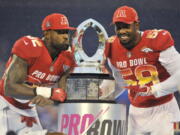 AFC linebacker Von Miller (58), of the Denver Broncos and tight end Delanie Walker (82), of the Tennessee Titans, pose with the NFL Pro Bowl trophy after defeating the AFC 24-23, in Orlando, Fla., Sunday, Jan. 28, 2018.