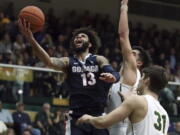 Gonzaga’s Josh Perkins, left, lays up a shot over San Francisco’s Erik Poulsen (31) during the first half of an NCAA college basketball game Saturday, Jan. 13, 2018, in San Francisco.