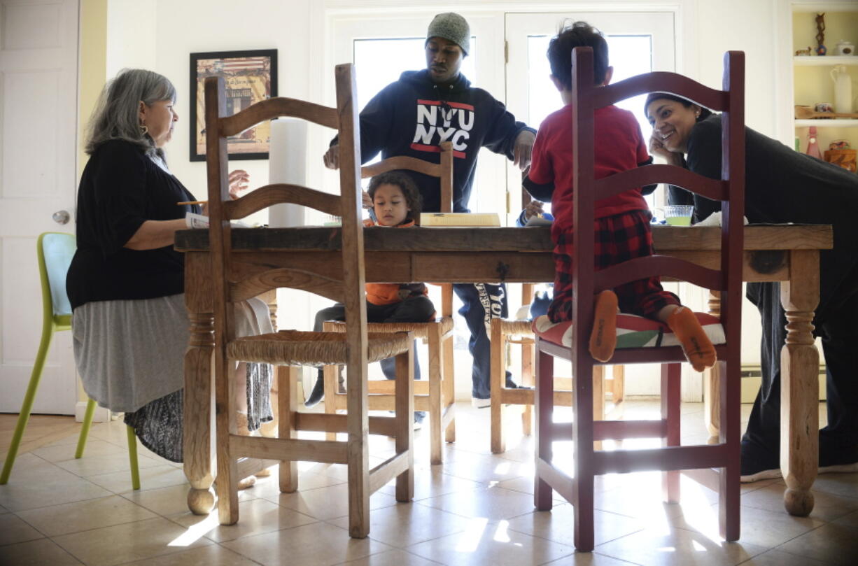 Artist and author Maybeth Morales, left, leads a home school art class Friday for her grandchildren as her daughter Chemay Morales-James, right, and son-in-law Shane, center, watch in Watertown, Conn.