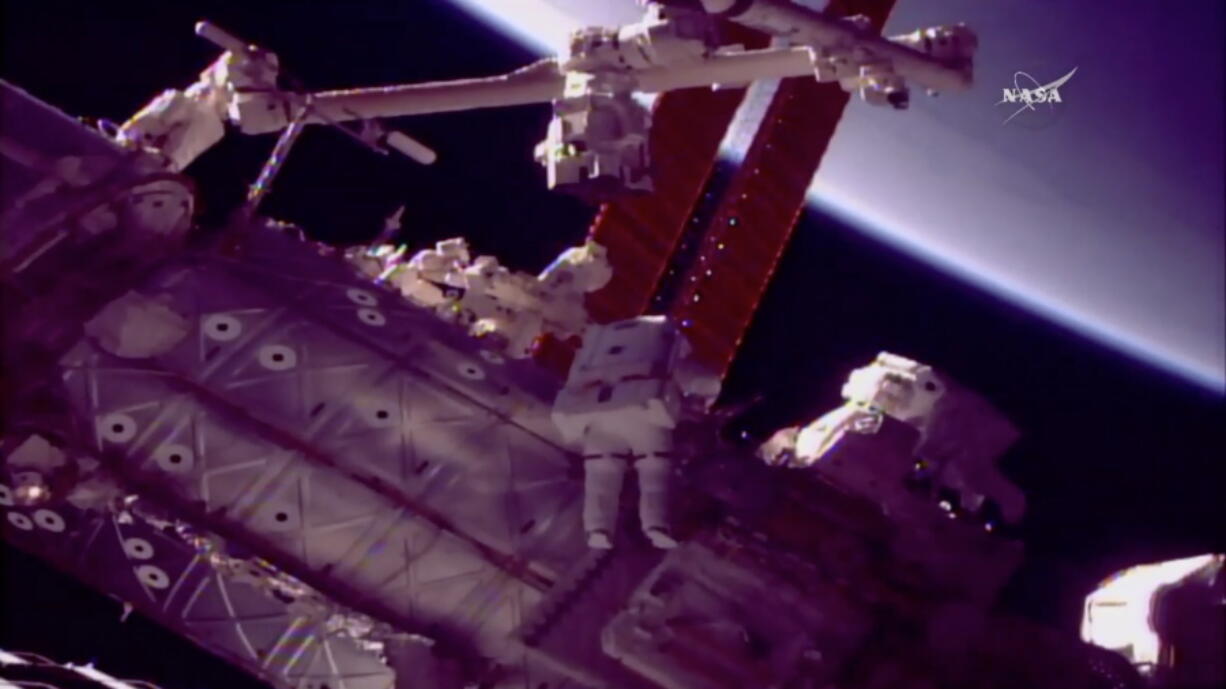 NASA astronauts Mark Vande Hei, left, and Scott Tingle work outside the International Space Station on Tuesday, Jan. 23, 2018, to give the robot arm a new hand.